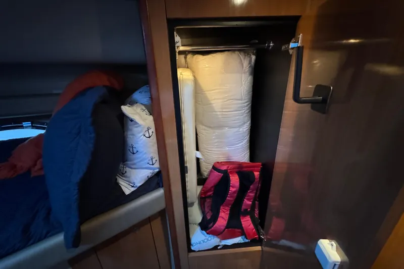 Slide: The Image of Interior storage of 2008 Cruisers Yachts 395 Motoryacht with bedding and red bag. - 53