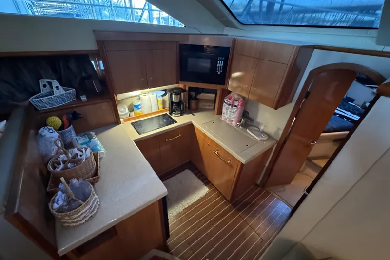 Slide: The Image of 2008 Cruisers Yachts 395 Motoryacht kitchen with wooden cabinets and modern appliances. - 24