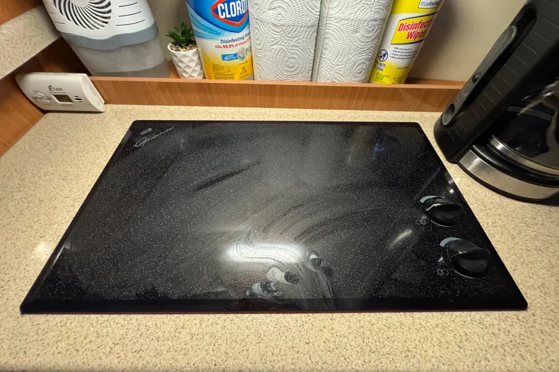 Slide: The Image of 2008 Cruisers Yachts 395 Motoryacht kitchen with electric stovetop and cleaning supplies. - 26