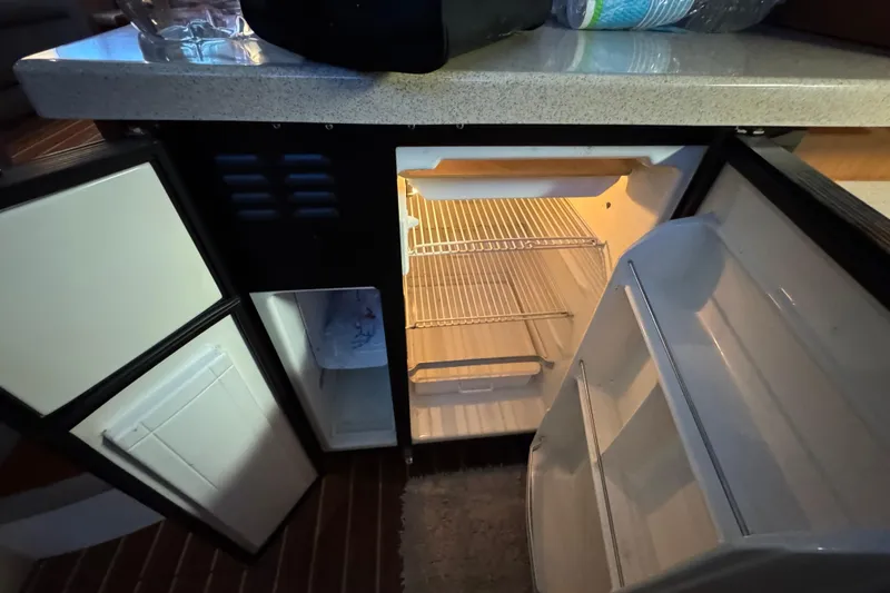 Slide: The Image of 2008 Cruisers Yachts 395 Motoryacht interior fridge with open doors and countertop. - 28