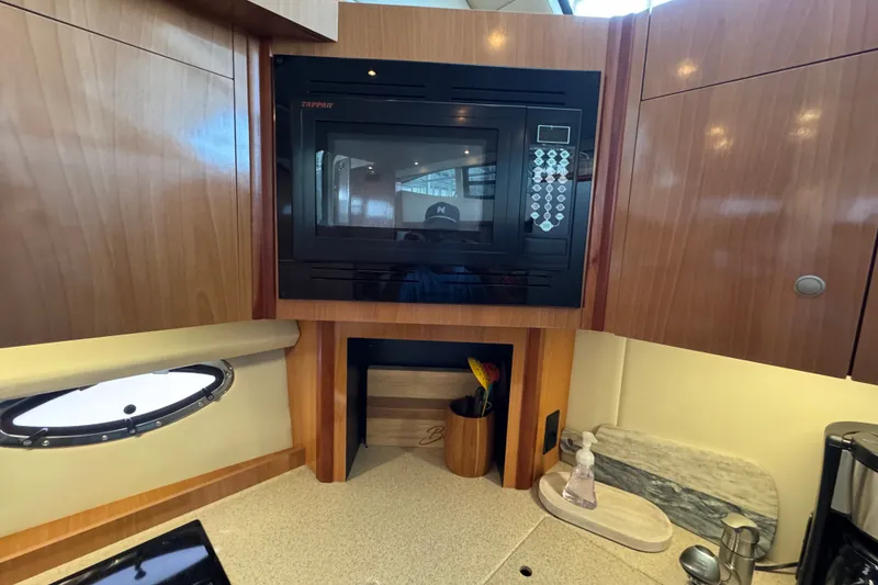 Slide: The Image of 2008 Cruisers Yachts 395 Motoryacht kitchen with microwave and wooden cabinetry. - 42