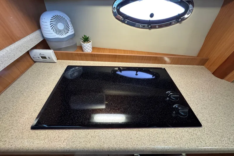 Slide: The Image of 2008 Cruisers Yachts 395 Motoryacht kitchen with sleek black cooktop and modern design. - 45
