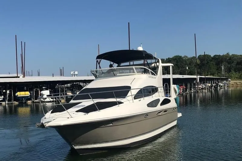 Slide: The Image of 2008 Cruisers Yachts 395 Motoryacht docked in a marina under clear blue skies. - 2