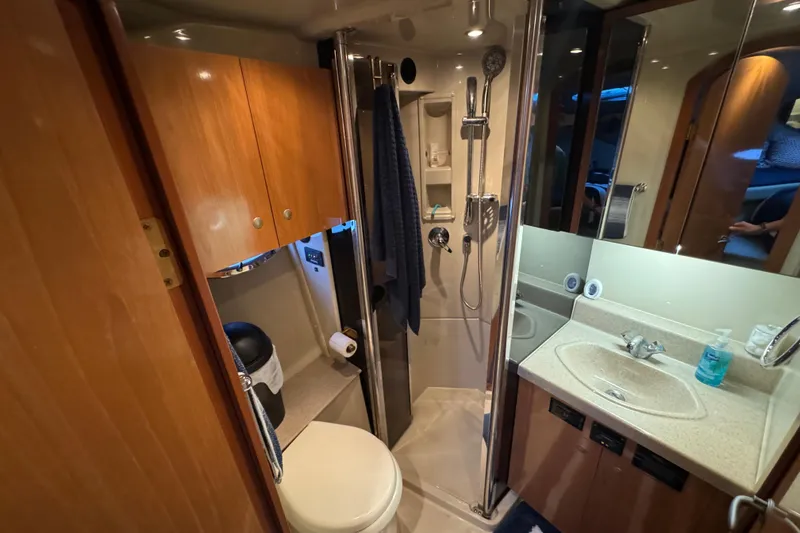 Slide: The Image of 2008 Cruisers Yachts 395 Motoryacht bathroom with shower, sink, and wooden cabinetry. - 34
