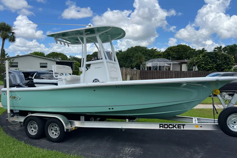 The Image of 2024 Sea Hunt BX 22 BR boat on trailer, parked outdoors under a cloudy sky. - 1