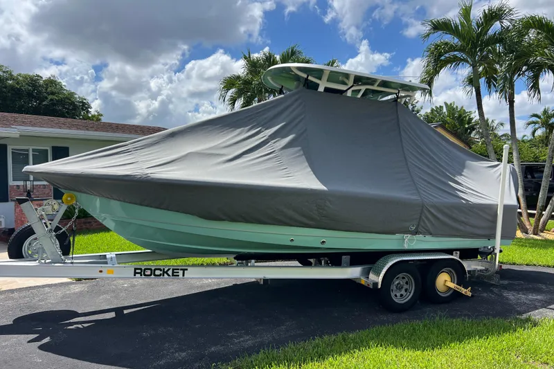 Slide: The Image of 2024 Sea Hunt BX 22 BR boat covered on trailer, parked in driveway. - 10