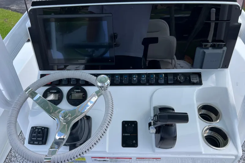 Slide: The Image of 2024 Sea Hunt BX 22 BR boat dashboard with steering wheel, controls, and Garmin display. - 18