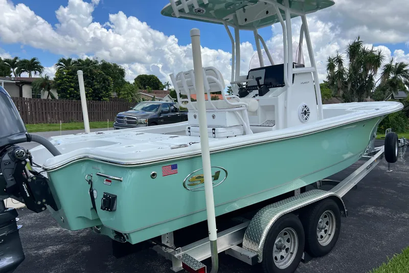 Slide: The Image of 2024 Sea Hunt BX 22 BR boat on trailer, light blue hull, parked outdoors. - 7