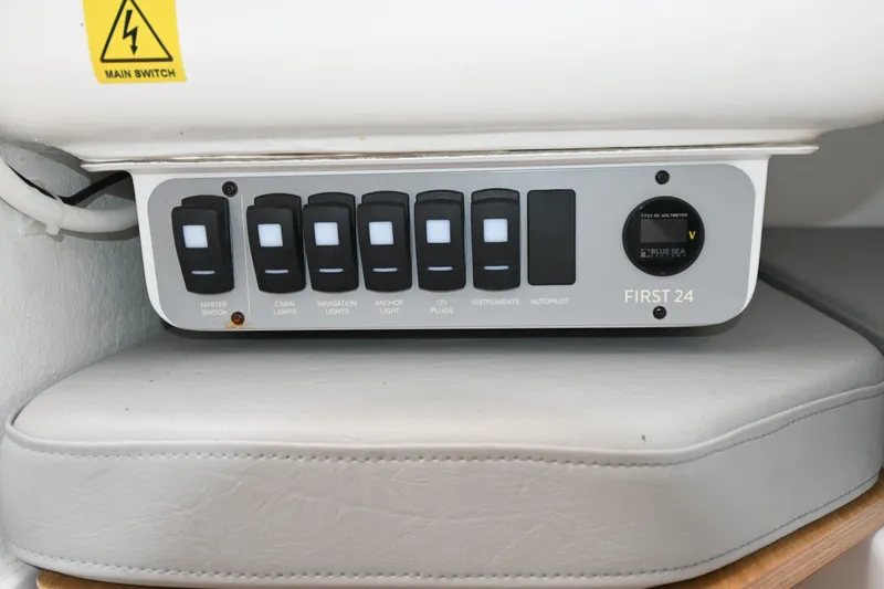 Slide: The Image of Control panel of a 2022 Beneteau First 24 sailboat with labeled switches. - 13