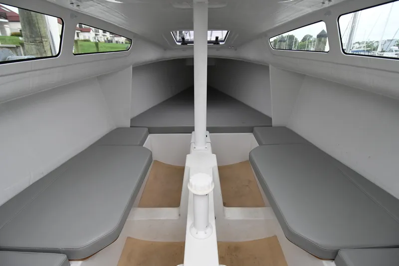 Slide: The Image of Interior of 2022 Beneteau First 24 sailboat, featuring minimalist cabin design with seating. - 2