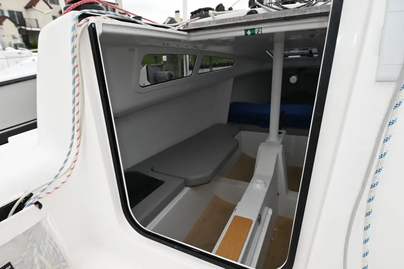 Slide: The Image of Interior view of 2022 Beneteau First 24 sailboat cabin, showcasing seating and compact design. - 20