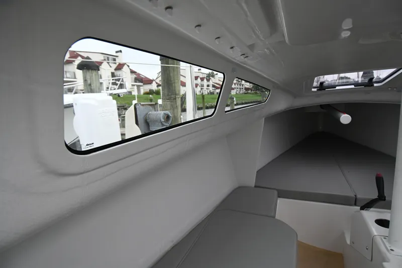 Slide: The Image of Interior view of 2022 Beneteau First 24 sailboat cabin with seating and windows. - 24