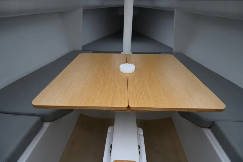 Slide: The Image of Interior of 2022 Beneteau First 24 sailboat with wooden table and seating. - 25