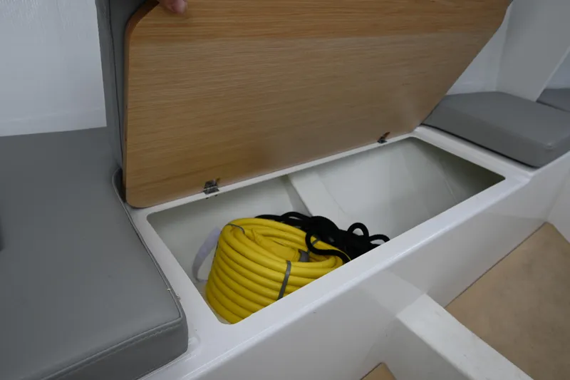 Slide: The Image of Storage compartment in 2022 Beneteau First 24 sailboat with yellow rope inside. - 30