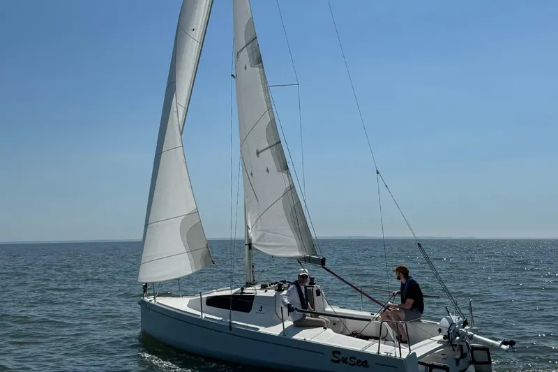 Slide: The Image of 2022 Beneteau First 24 sailboat on open water with two people onboard. - 32