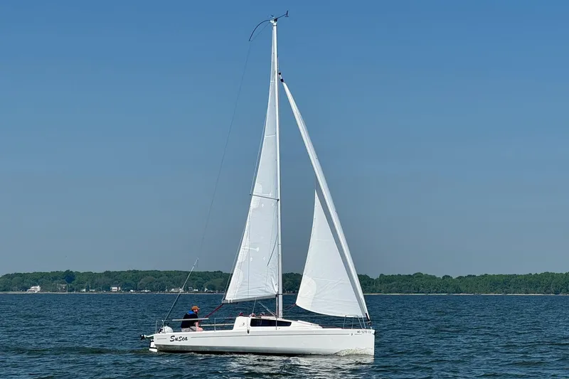 Slide: The Image of 2022 Beneteau First 24 sailboat on calm water under clear blue sky. - 33