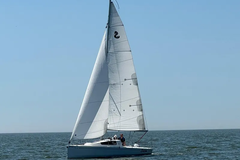 Slide: The Image of 2022 Beneteau First 24 sailboat gliding on open water under clear blue sky. - 4