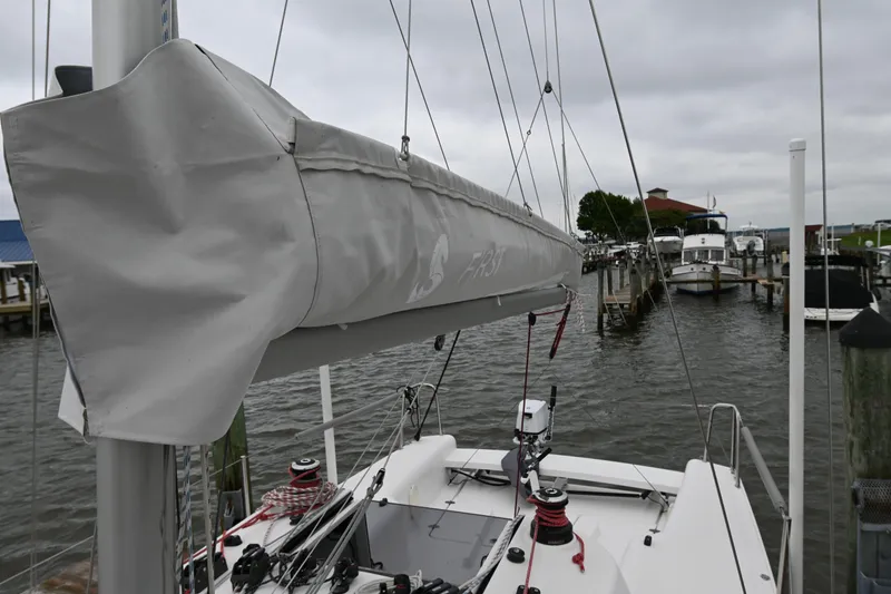 Slide: The Image of 2022 Beneteau First 24 sailboat docked at a marina, featuring covered boom and rigging. - 9