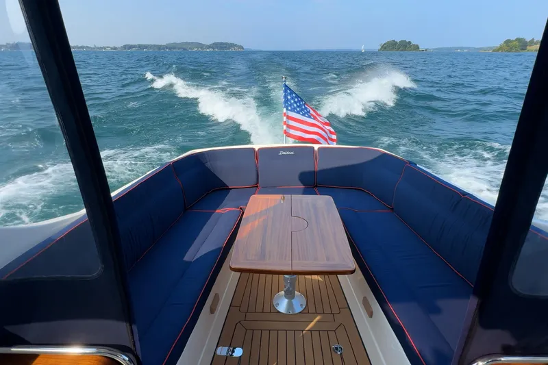 Slide: The Image of 2024 DaVinci 30HT boat interior with American flag, cruising on open water. - 10