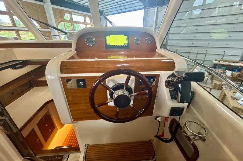 Slide: The Image of 2024 DaVinci 30HT boat helm with wooden dashboard and modern controls. - 21