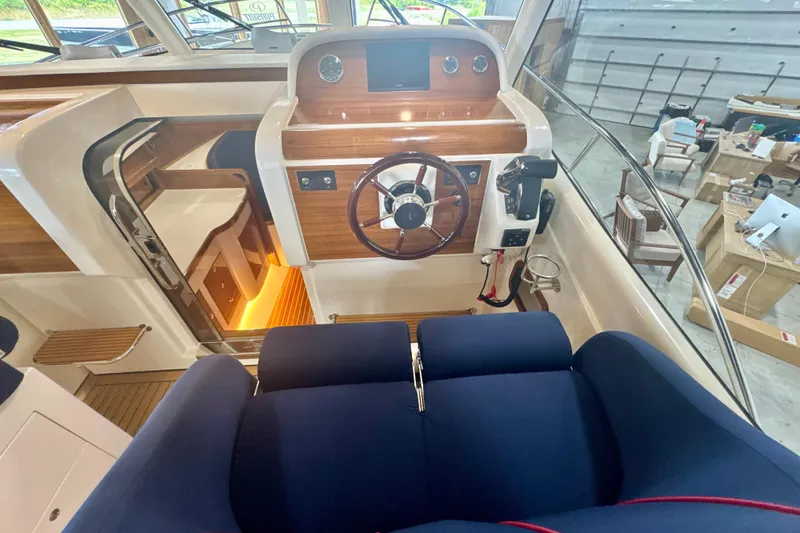 Slide: The Image of 2024 DaVinci 30HT boat interior with wooden dashboard and blue seating. - 36