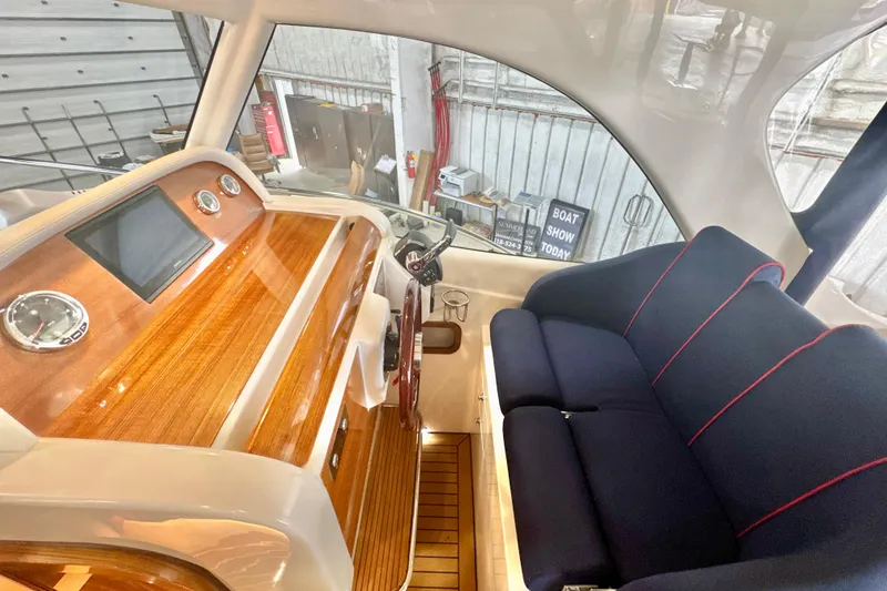 Slide: The Image of 2024 DaVinci 30HT boat interior with wooden dashboard and navy seating. - 38