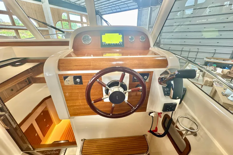 Slide: The Image of 2024 DaVinci 30HT boat helm with wooden dashboard and modern controls. - 42