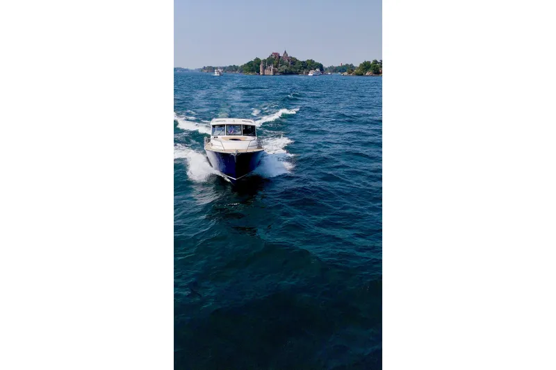Slide: The Image of 2024 DaVinci 30HT boat cruising on a scenic blue lake. - 6