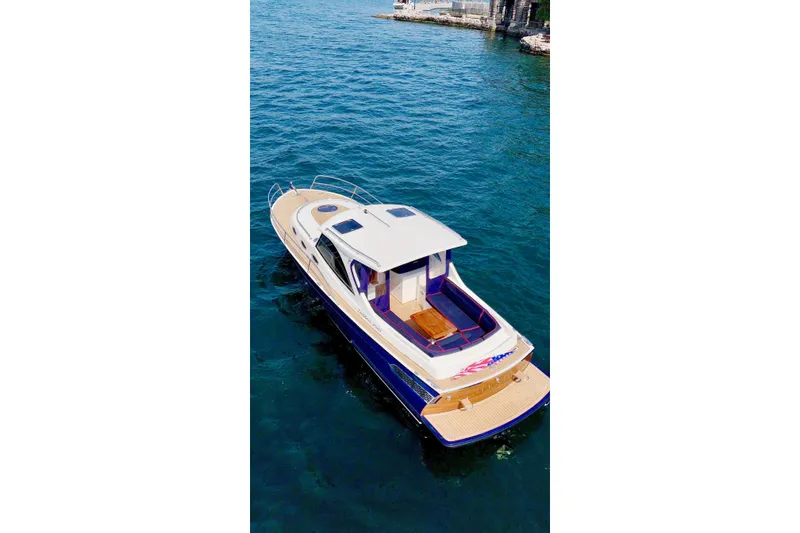 Slide: The Image of 2024 DaVinci 30HT boat on clear blue water, showcasing sleek design and spacious deck. - 8