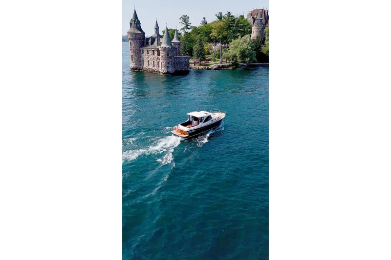 Slide: The Image of 2024 DaVinci 30HT boat cruising near a historic castle on a serene lake. - 9
