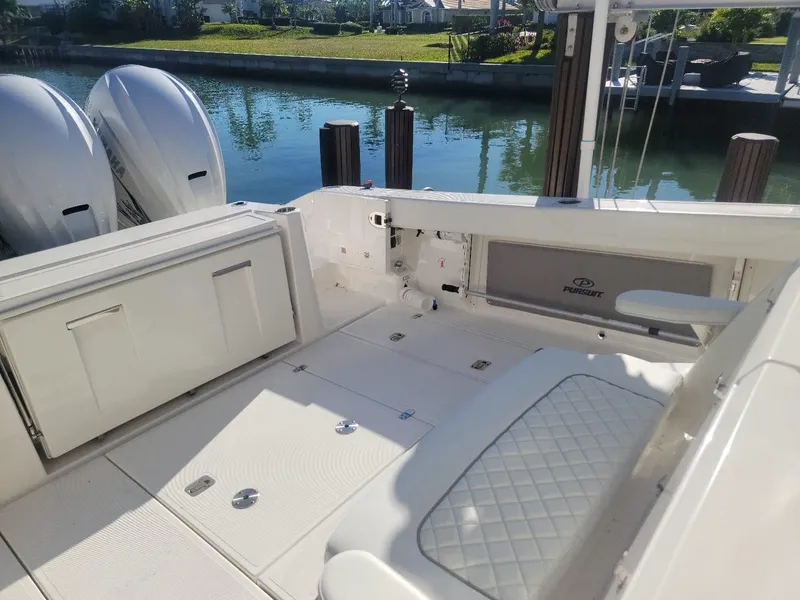 Slide: The Image of 2021 Pursuit S 378 Sport boat interior with twin engines, docked by a canal. - 22