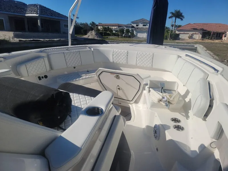 Slide: The Image of 2021 Pursuit S 378 Sport boat interior with white seating and storage compartments. - 28