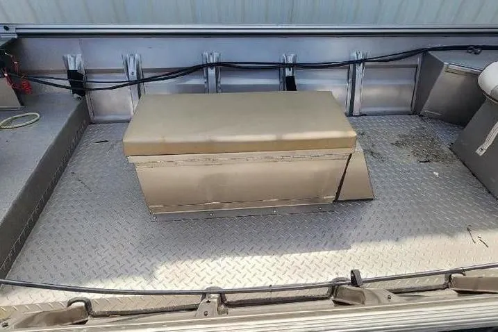 Slide: The Image of 2012 War Eagle 1642 Stick Steer boat interior with metal flooring and storage box. - 4