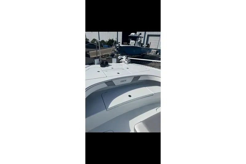 Slide: The Image of 2024 Costa Custom Boats 260, sleek deck view at a marina. - 4