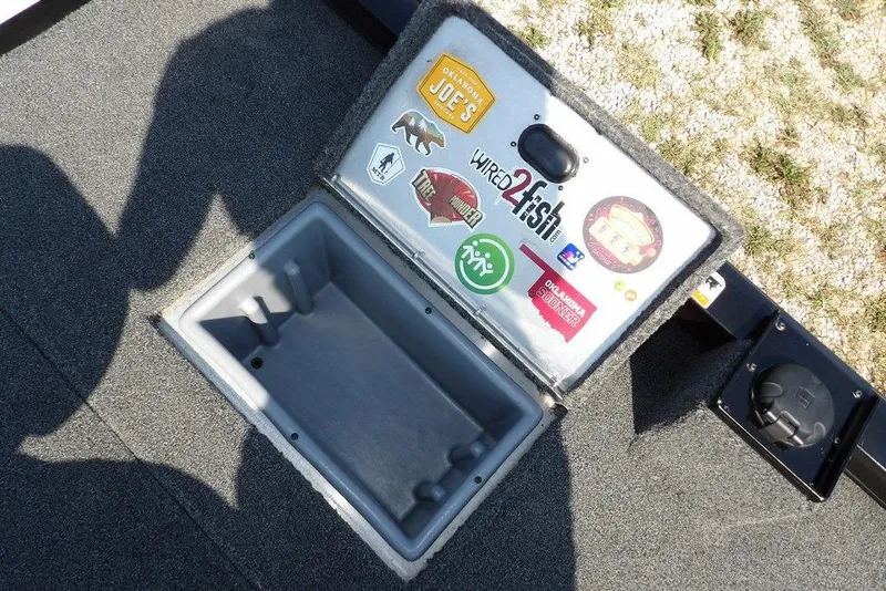 Slide: The Image of Open storage compartment on 2013 Lowe Stinger ST175 boat with various stickers on the lid. - 12