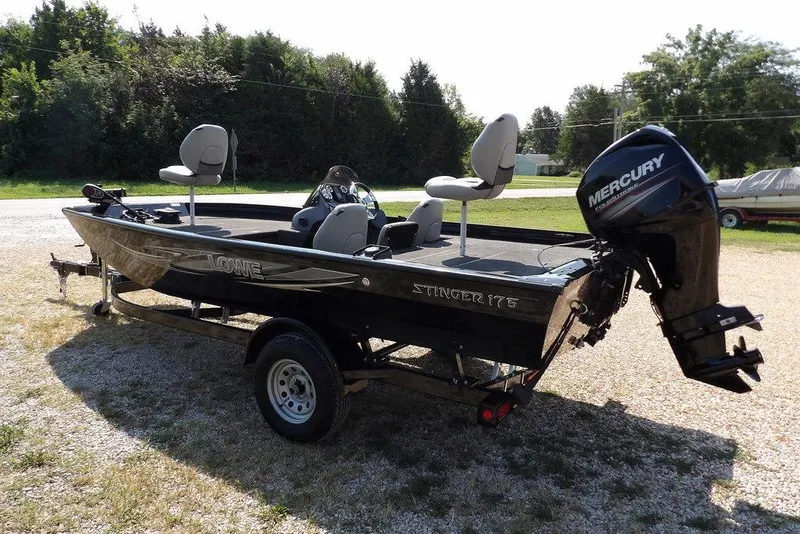 Slide: The Image of 2013 Lowe Stinger ST175 boat with Mercury engine on a trailer, parked outdoors. - 2