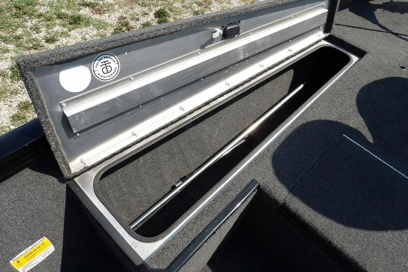 Slide: The Image of Open storage compartment in 2013 Lowe Stinger ST175 boat, featuring carpeted interior. - 29