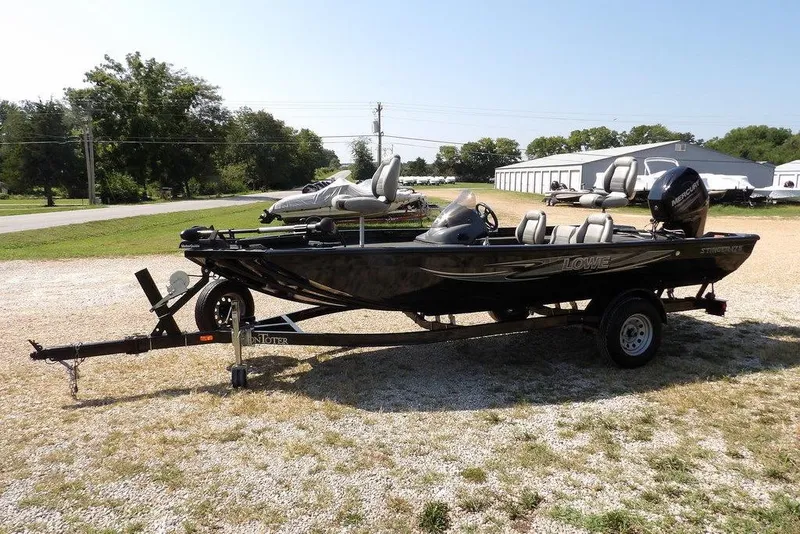 Slide: The Image of 2013 Lowe Stinger ST175 boat on trailer, parked outdoors in a sunny setting. - 4