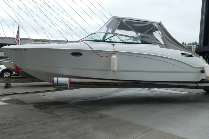 Slide: The Image of 2014 Formula 290 Sun Sport boat on a lift, with canopy and docked fenders. - 3
