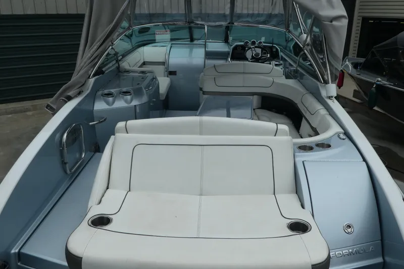 Slide: The Image of 2014 Formula 290 Sun Sport boat interior with seating and helm, docked under cover. - 4