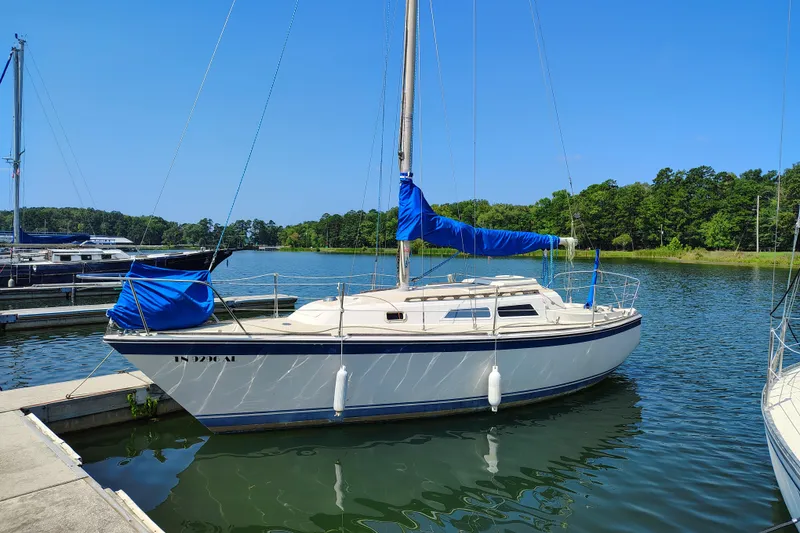 Slide: The Image of 1979 O'Day 28 sailboat docked in a serene marina with clear blue skies. - 0