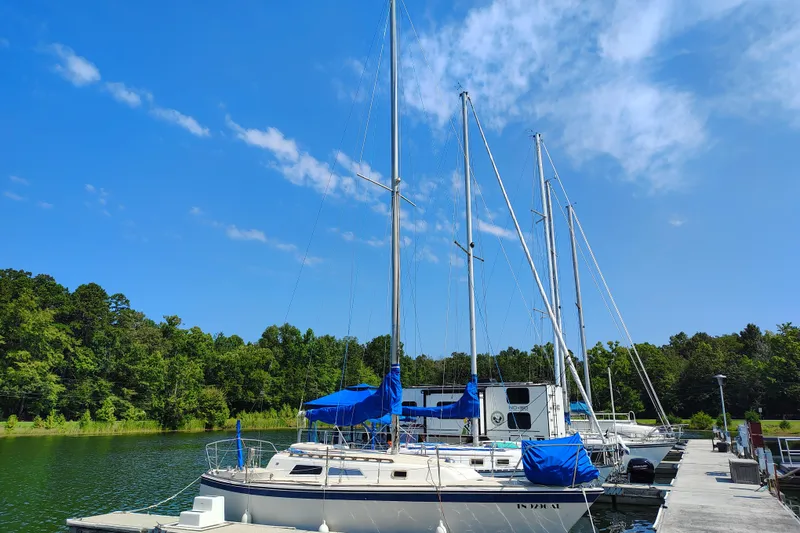 Slide: The Image of 1979 O'Day 28 sailboat docked on a serene lake under a clear blue sky. - 1