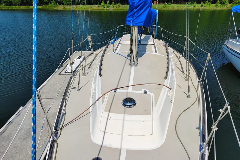 Slide: The Image of 1979 O'Day 28 sailboat docked on calm water, featuring a clean deck and blue cover. - 15