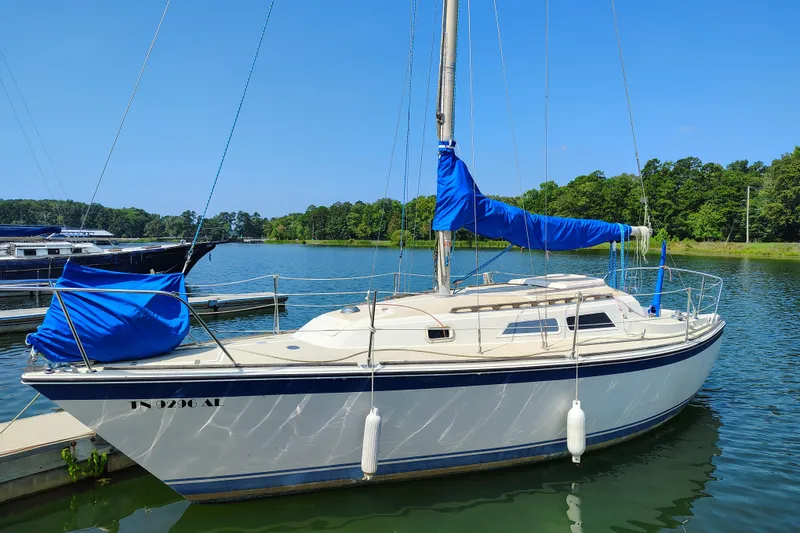 Slide: The Image of 1979 O'Day 28 sailboat docked on a serene lake under a clear blue sky. - 2