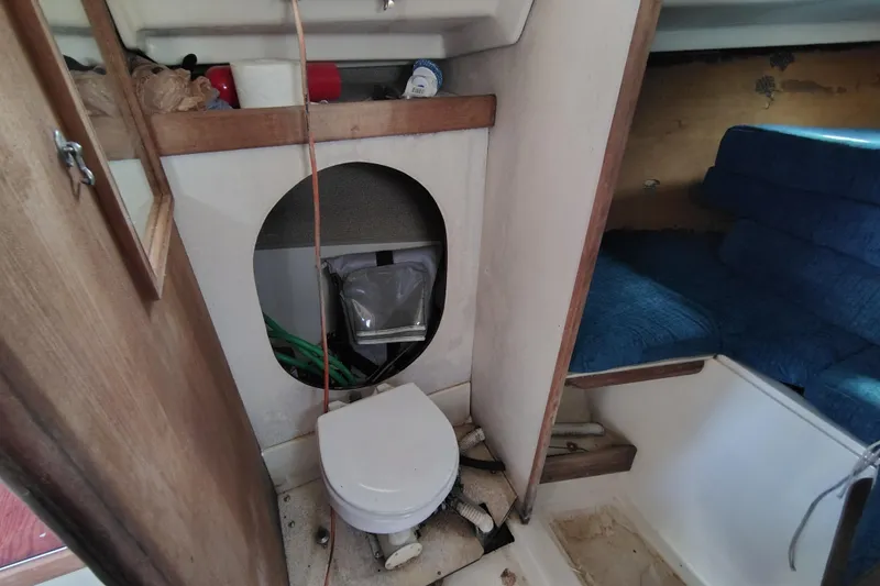 Slide: The Image of 1979 O'Day 28 sailboat interior with toilet and blue seating area. - 28