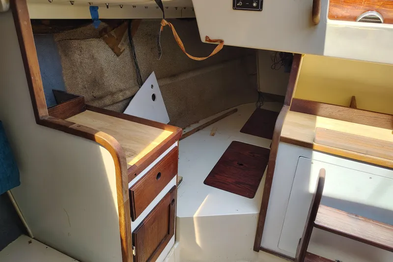 Slide: The Image of Interior of a 1979 O'Day 28 sailboat featuring wooden cabinetry and seating area. - 29