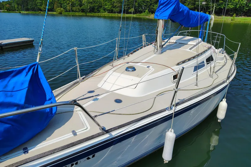 Slide: The Image of 1979 O'Day 28 sailboat docked on a serene lake with blue covers. - 3
