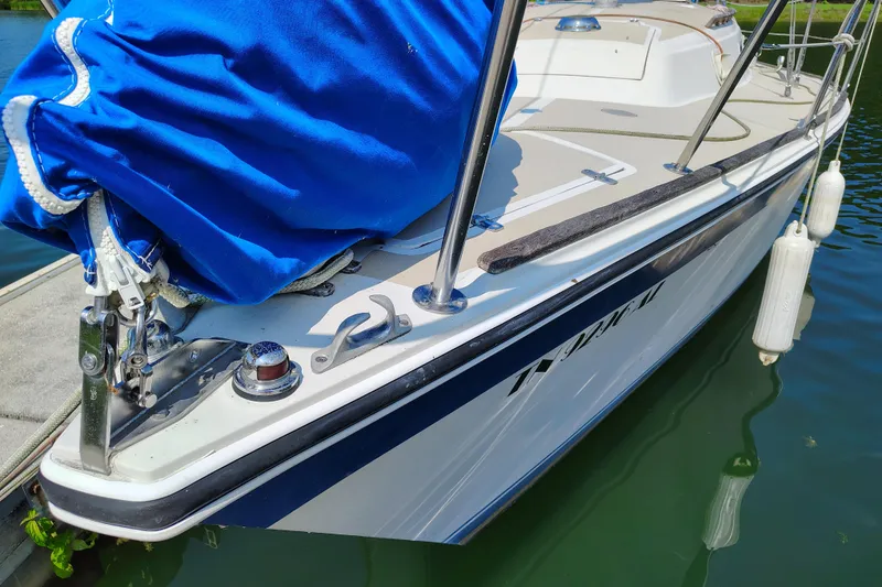 Slide: The Image of 1979 O'Day 28 sailboat docked, featuring blue cover and white hull. - 4