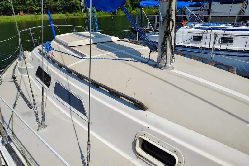 Slide: The Image of 1979 O'Day 28 sailboat deck with rigging and windows, docked near other boats. - 5