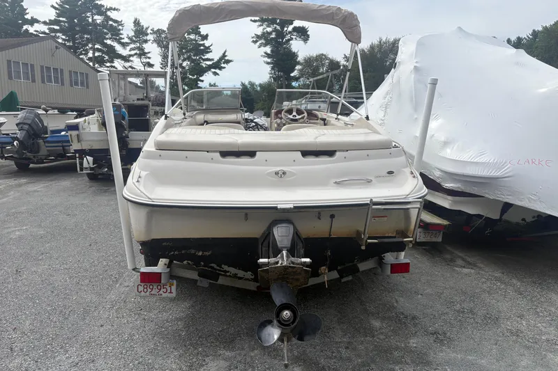 Slide: The Image of 2005 Glastron SX 175 boat, rear view, parked outdoors with other boats. - 2